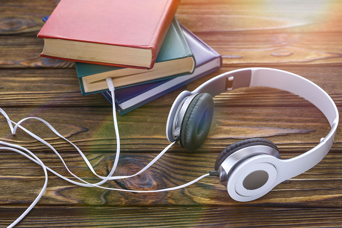 Photo of over-the-ear headphones with the wire 'plugged' into a stack of books
