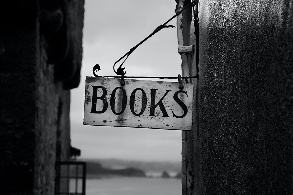 Black and white photo of old-fashioned store sign reading 'BOOKS'