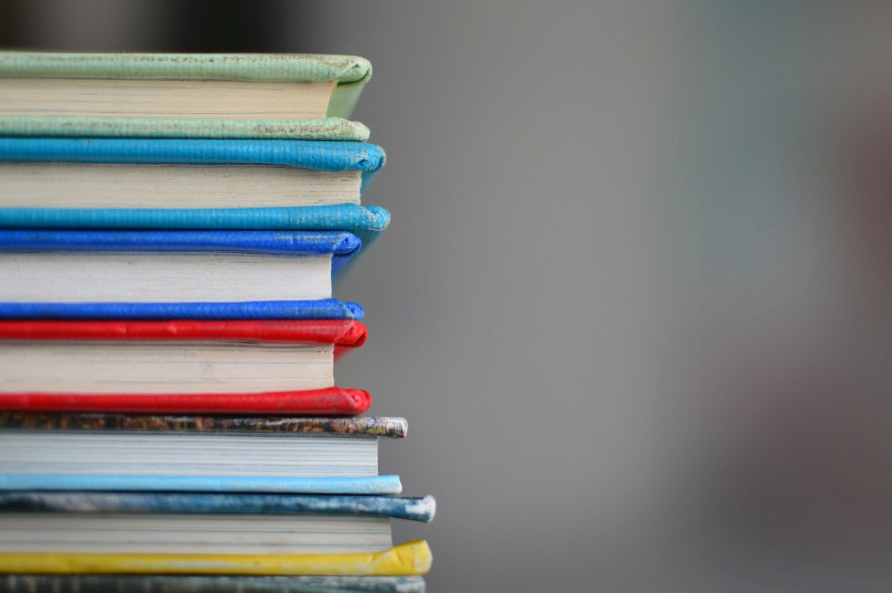 A stack of colorful books with a blurred background.