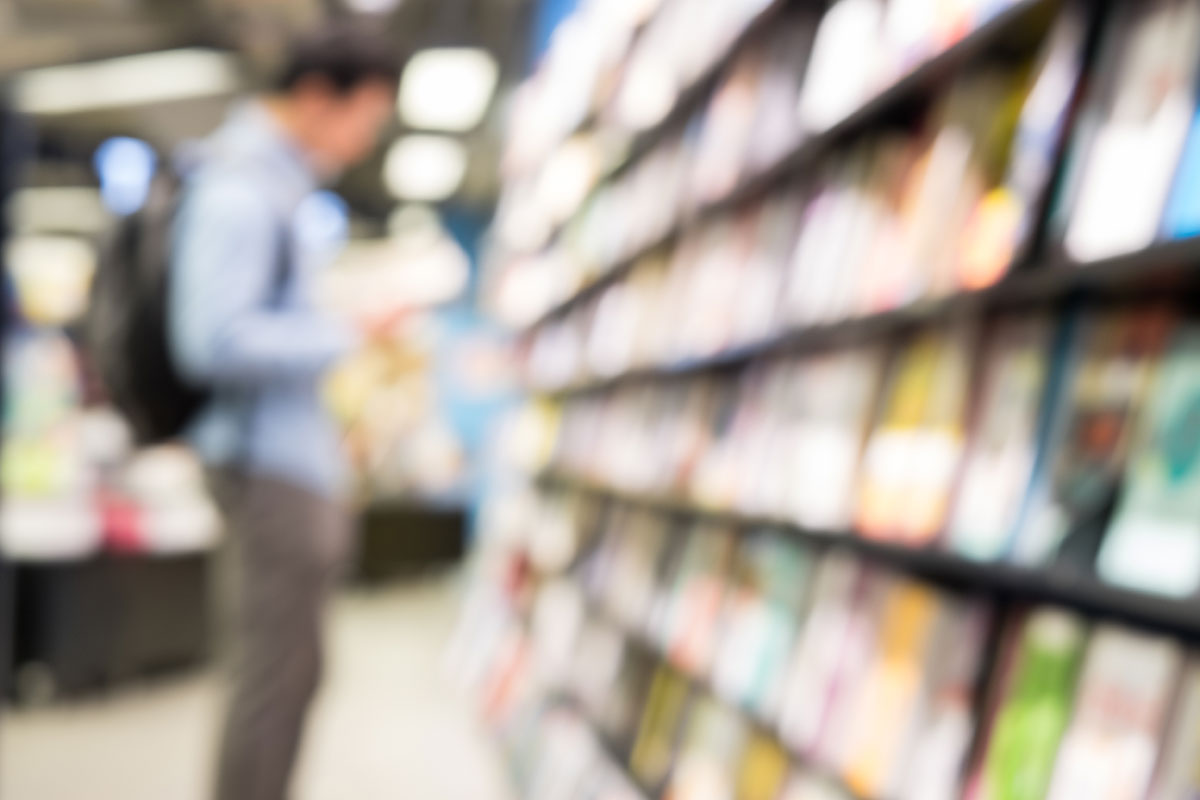 Artistically blurred photo of man browsing in bookstore